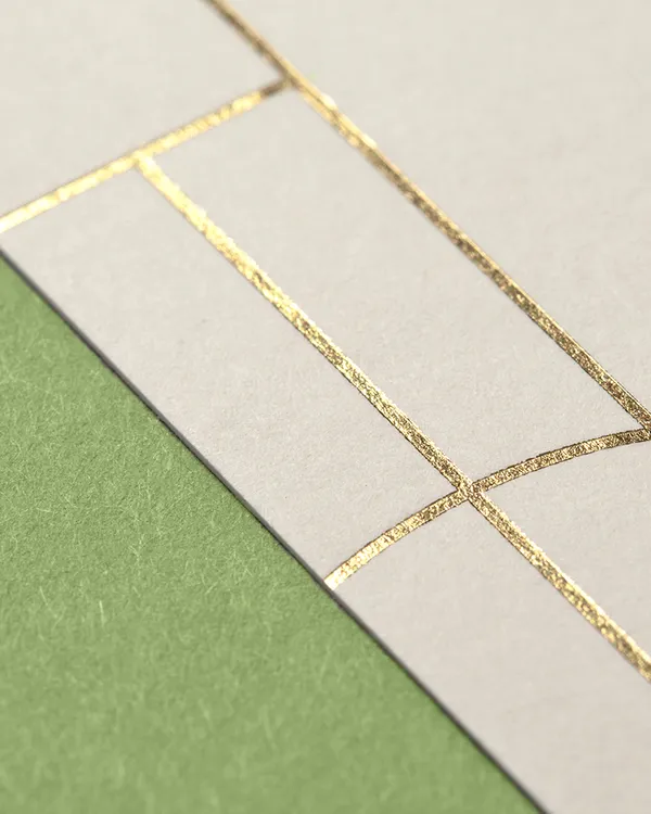 Detailaufnahme eines Flyers mit eleganter Heißfolienprägung in Gold auf mattem Naturpapier