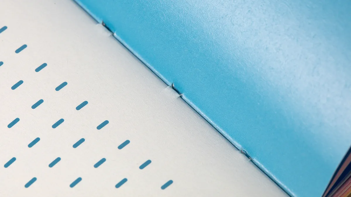 Buch mit sichtbarer Fadenheftung auf ungestrichenem Papier – minimalistisches Design mit Einschweißverpackung