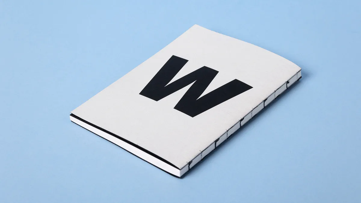 Detailansicht eines fadengehefteten Printprodukts mit offenem Rücken und minimalistischem Design